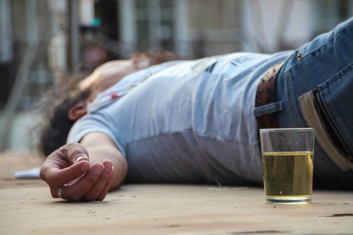 Man passed out by alcoholic drink