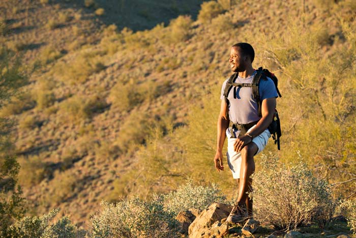 hiker standing on mountain on sunny day